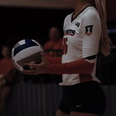 a female volleyball player holding a ball in her hands