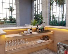 an empty bar with wine glasses and bottles on the counter in front of large windows