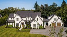 a large white house surrounded by trees and grass