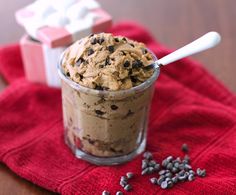 chocolate chip cookie ice cream in a glass on a red cloth next to some cookies