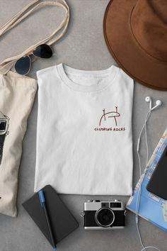 white cotton rock climbing t-shirt with quote that says "climbing rocks" and a funny illustration that looks like a rock with rock n roll hand gesture. minimalistic line art style and handwritten font in maroon color positioned on right side of the chest Rock Climbing Tshirt, Climbing Shirt, Climber Gifts, Shirt With Embroidery, Adventure Outfit, Rock Climbers, A Love Letter, Rock T Shirts, Rock Stars