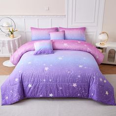 a purple and pink bed with stars on the comforter, pillows and pillowcases