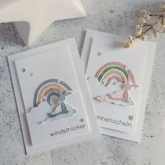 two cards with rainbows and clouds on them