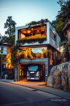 a large truck parked in front of a building with plants growing on it's roof