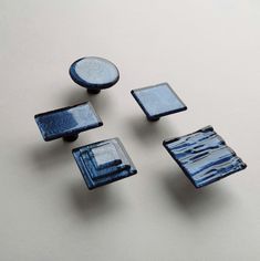 four pieces of blue glass sitting on top of a table