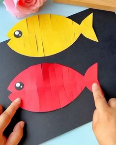 someone is making a fish out of construction paper