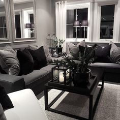 a black and white living room with couches, coffee table and mirror on the wall