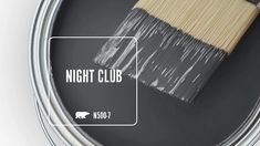 a paint can with the words night club painted on it and a brush next to it