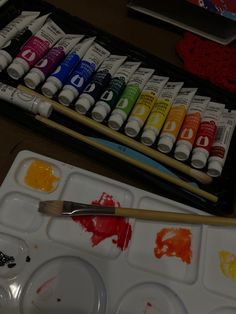 an artist's palette with paint and watercolors