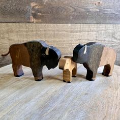 three wooden elephants standing on top of a table