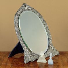 an ornate silver and blue mirror on a wooden table