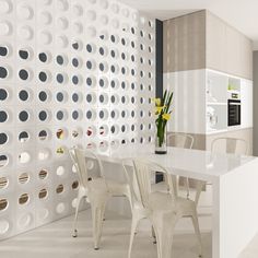 a white table with four chairs in front of it and a wall made out of circles