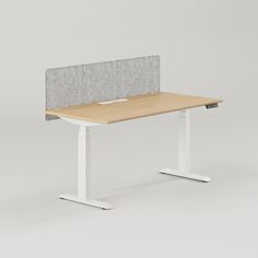 an office desk with a gray and white fabric privacy panel on the top, along with a light wood tabletop