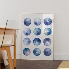 a framed print with eight pool balls in blue and white on the wall next to a chair