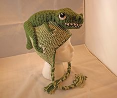 a crocheted hat with an alligator's head on top of a mannequin