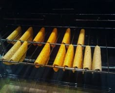 corn on the cob is being cooked in an oven with other food items inside