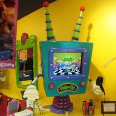 an electronic toy robot sitting on top of a table next to other toys and decorations