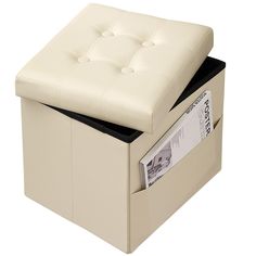 a white ottoman with an open drawer underneath it and some sort of money sticking out of the bottom