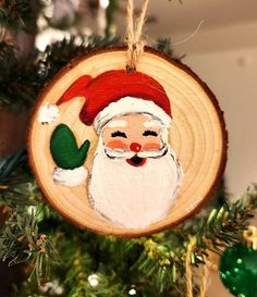 a wooden ornament with a santa clause on it hanging from a christmas tree