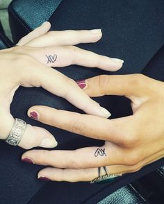 two hands with matching tattoos on their fingers