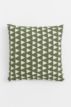 a green pillow with white triangles on it