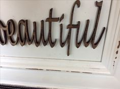 a sign that says beautiful hanging on the side of a wall in front of a door