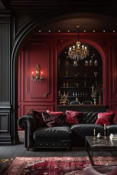 a living room filled with furniture and a chandelier hanging from the ceiling in front of a red wall