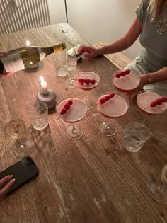 two women sitting at a table with wine glasses and desserts