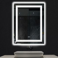 a bathroom sink with a lighted mirror above it