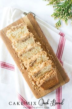 a loaf of cake sitting on top of a wooden cutting board next to a christmas tree