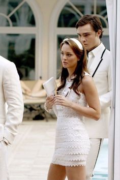 a man and woman dressed in white standing next to each other