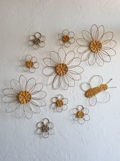 the wall is decorated with metal flowers and wire work on each flower's petals