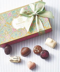 an assortment of assorted chocolates in a gift box with a bow on top