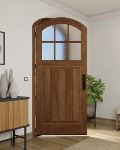 an open wooden door in a living room next to a table with vases on it