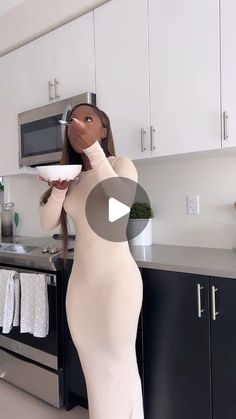 a woman standing in a kitchen holding a plate