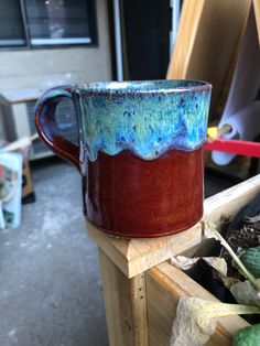 a blue and red mug sitting on top of a wooden table