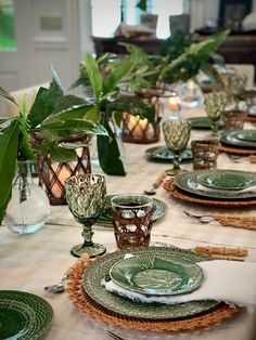 the table is set with green dishes and place settings