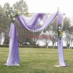 an outdoor wedding set up with purple drapes and flowers