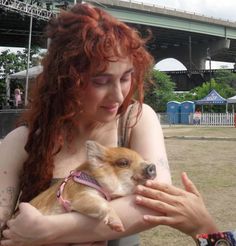 a woman holding a small dog in her arms