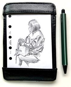 a pencil and pen sitting on top of a notebook with a drawing of a woman