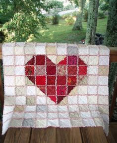 a red heart quilt on a wooden deck