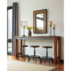 a table with three stools and a mirror on the wall above it in a living room