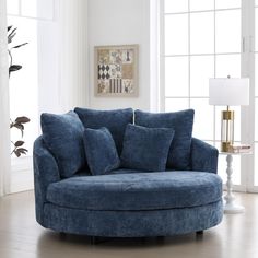 a living room with a blue couch and pillows on the chair in front of a window