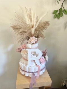 a three tiered cake decorated with flowers and feathers