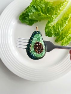 a person holding a fork over a white plate with lettuce and other food on it