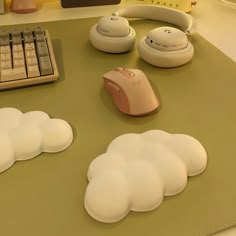 there are many cloud shaped objects on the desk top, including a computer mouse and keyboard