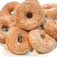 a pile of sugared donuts sitting on top of a white plate