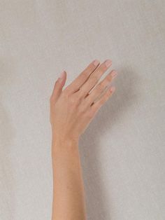 a woman's hand reaching for something on the wall