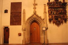 an old church with ornate carvings on the wall and wooden doors in front of it