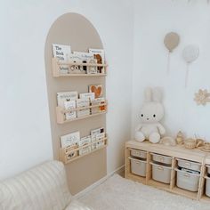 there is a teddy bear and some books on the shelf in this room with white walls